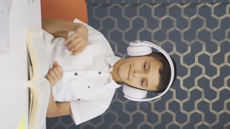 Vertical-video-of-Boy-listening-to-music-with-headphones-at-home